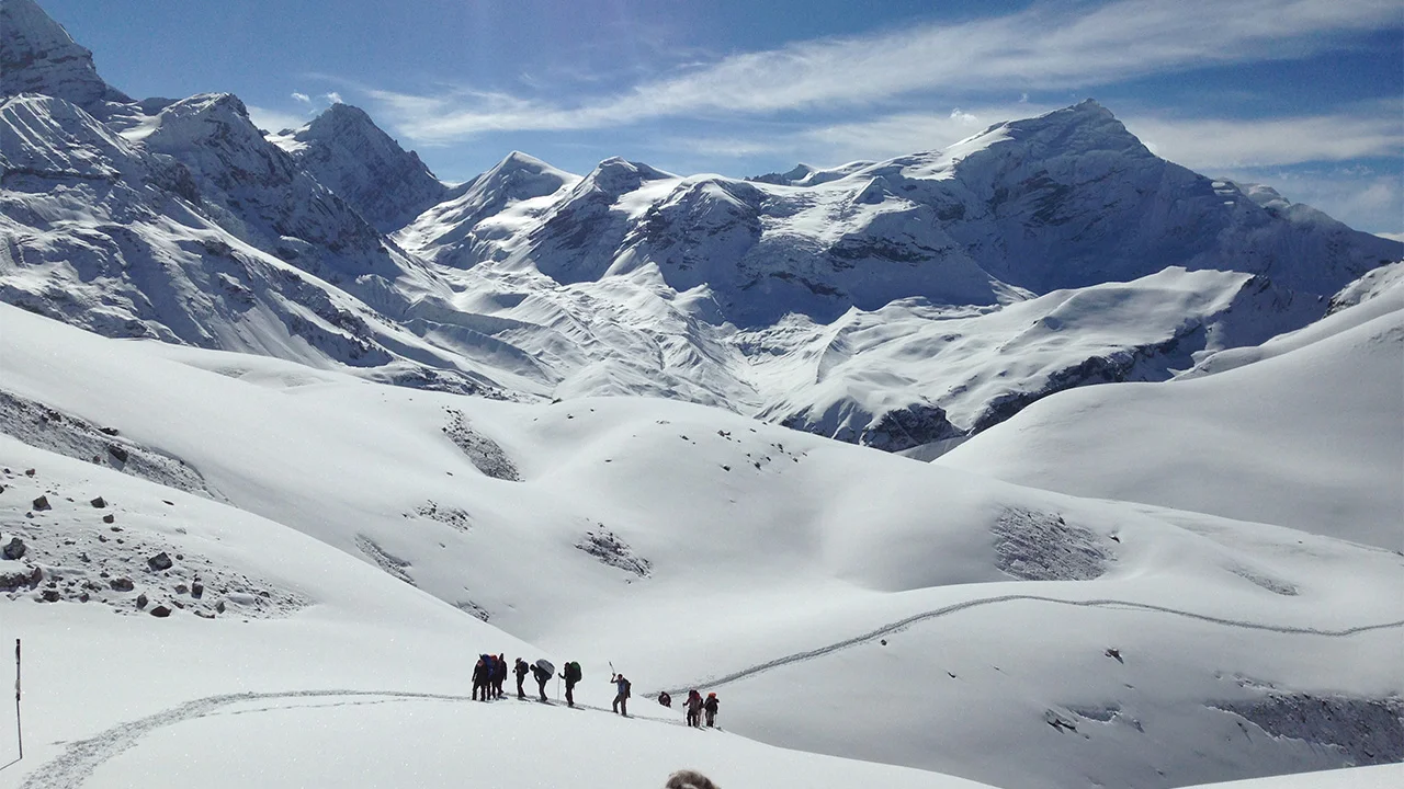 A line of trekkers walking on the snow towards Thorong-La Pass during the trekking expedition in the Himalayas of Nepal.