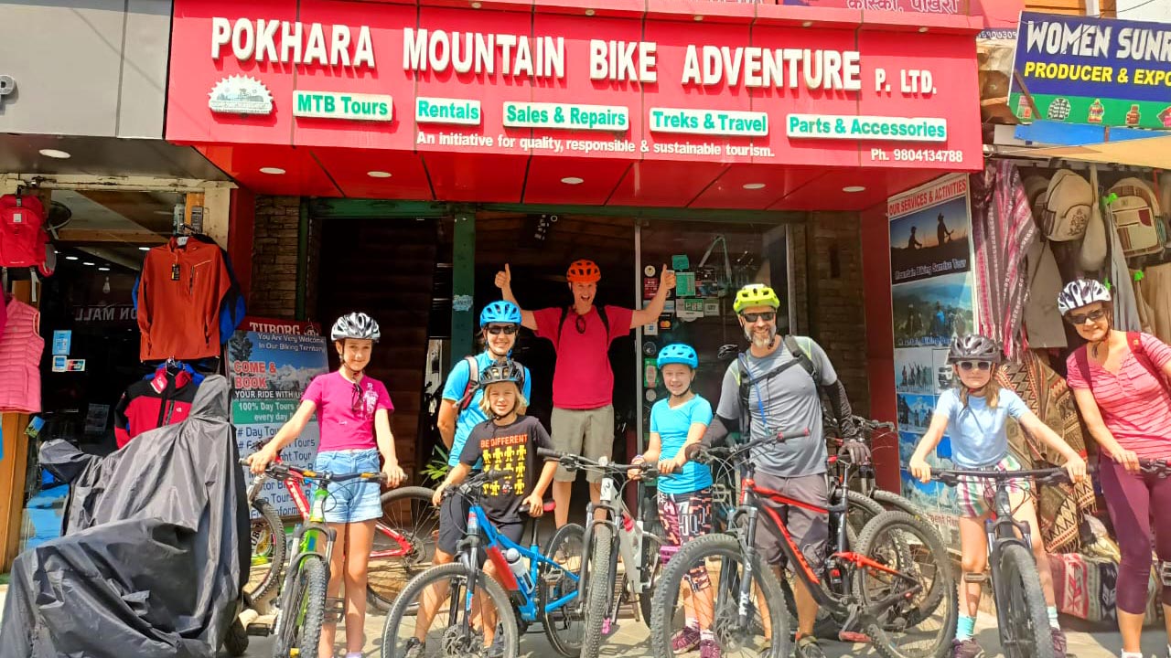 A group of bikers are posing for a picture before setting up for a mountain bike tour in Pokhara.